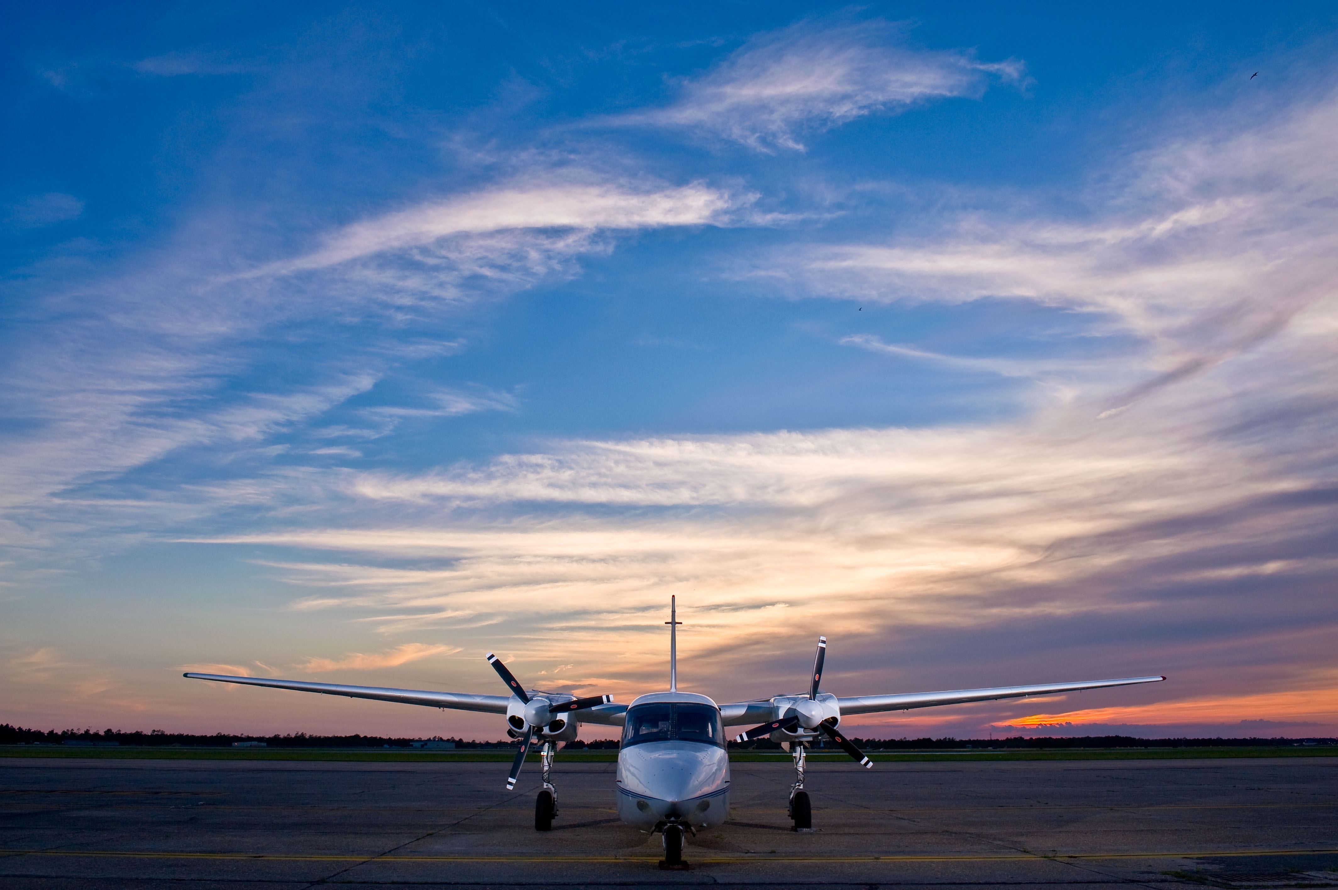 Twin-engine aircraft on the tarmac at sunset