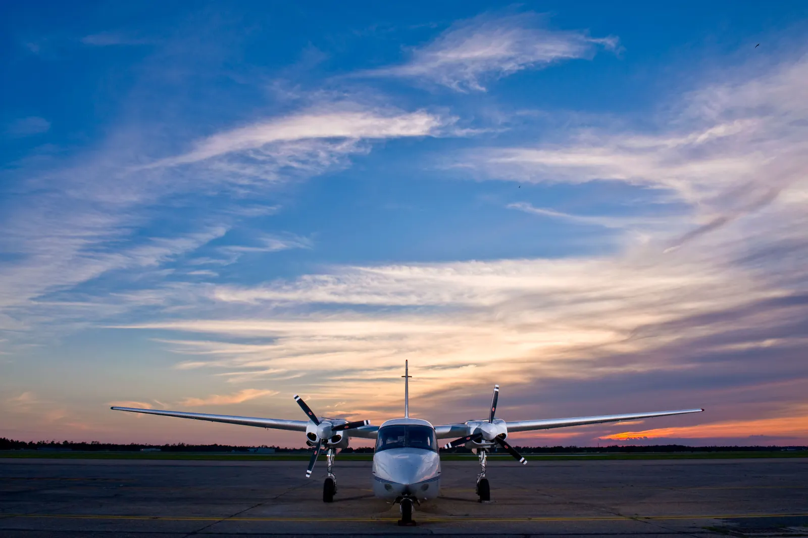 Twin-engine aircraft on the tarmac at sunset
