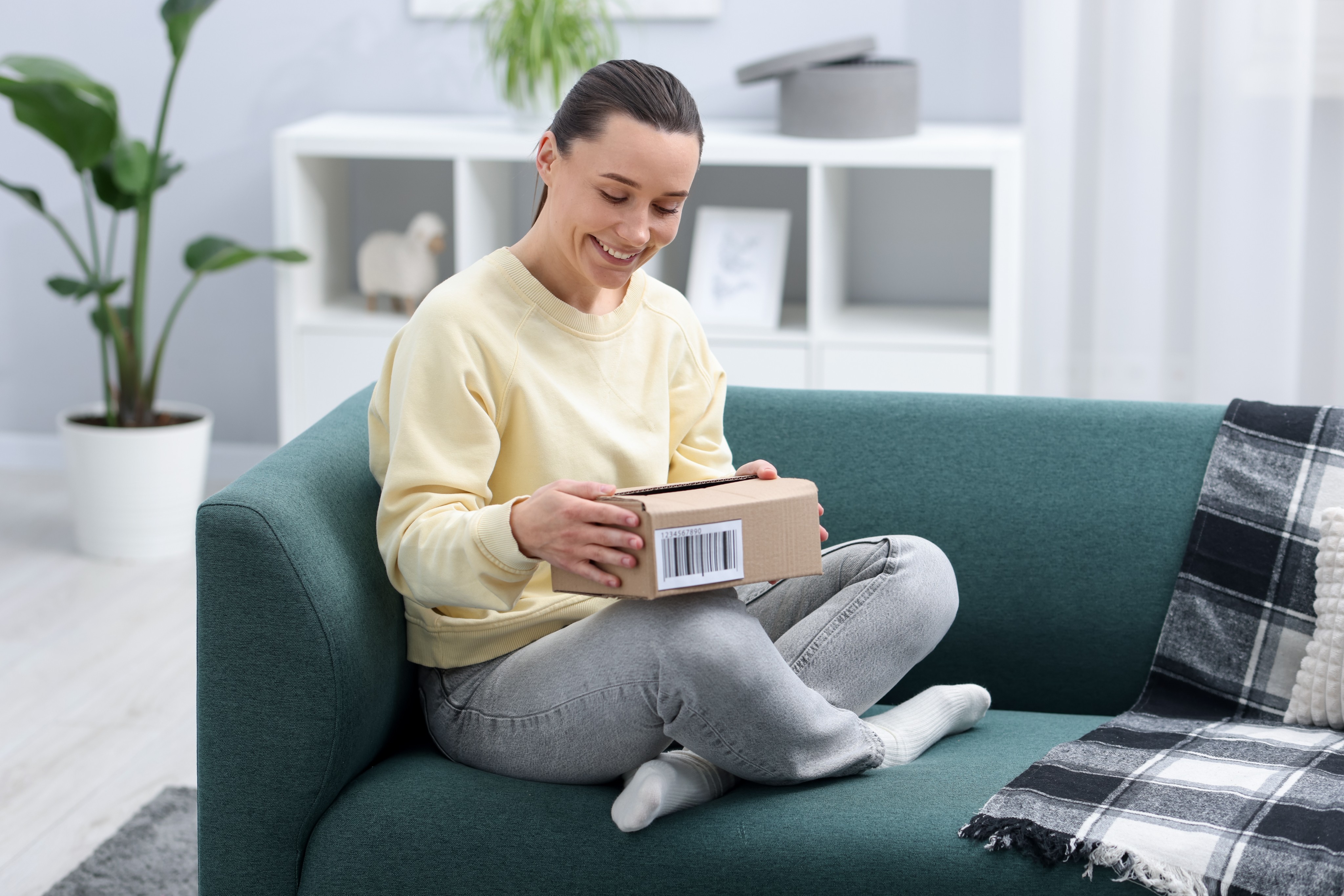 Woman happily receiving a forwarded package at home